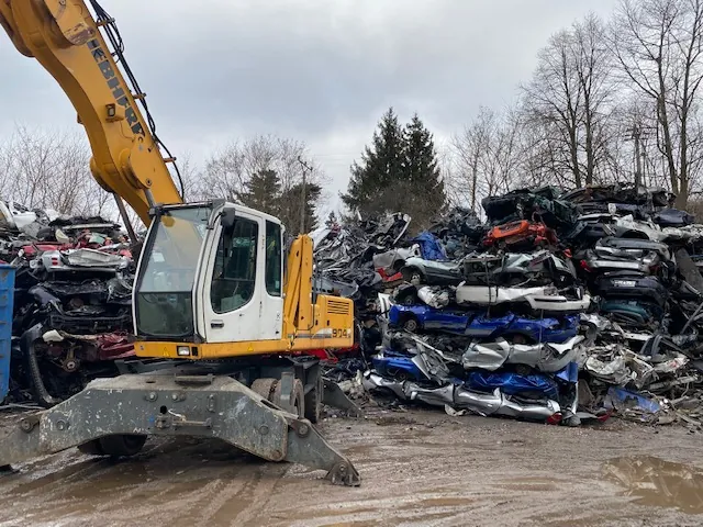 Manipulátor Liebherr nakládá lisované autovraky na výkupně kovů AB Metal Recycling